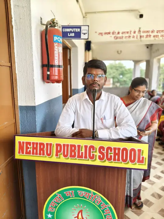 A teacher speaks from the school podium on Teachers' Day