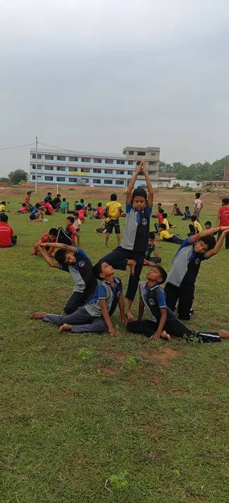A balanced group yoga formation on the school ground